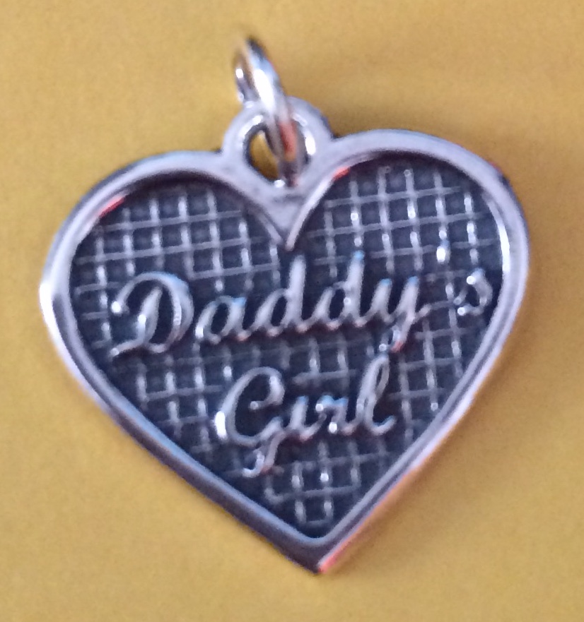 A silver heart pendant engraved “Daddy's Girl”